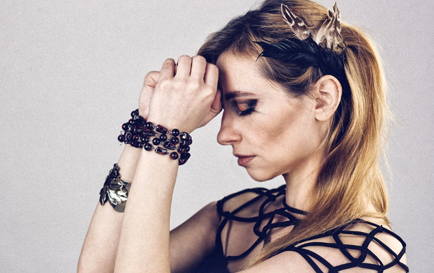 Protect Yourself from Emotional Burnout with the Empath’s “Bill of Rights” a woman with eyes closed resting her forehead on her closed fists with her hands in beaded "shackles"