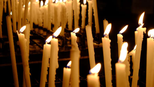 Celebration and Release -- Acceptance and Letting Go tapered candles burning, and some are extinguished.
