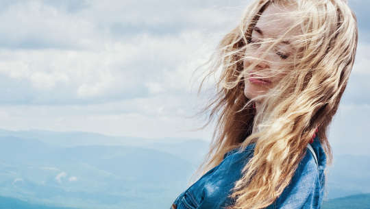 Freeing the Female Orgasm woman with eyes closed and the wind blowing through her hair