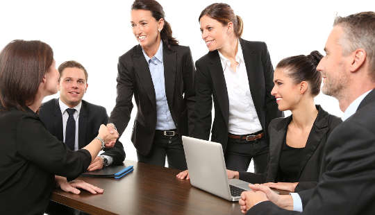 Why It’s So Difficult to Engage Men as Allies and How To Change That women shaking hands at a business meeting, with men loooking on