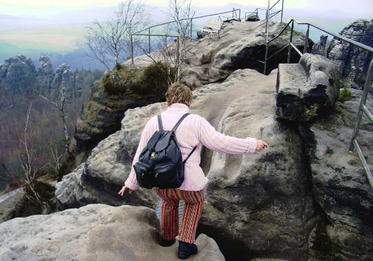 Today's Inspiration: December 14, 2022 older woman wearing a backpack climbing a rocky path
