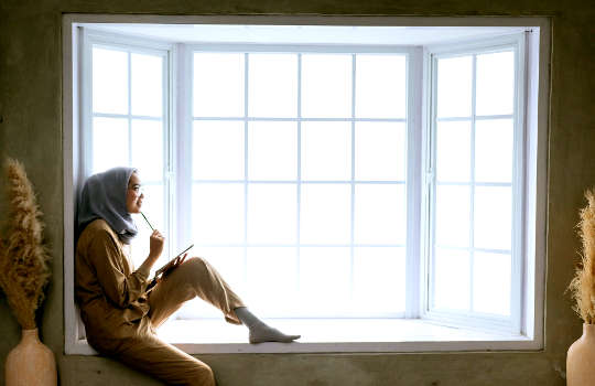 Living Wild, Loving Free: The Practice of Compassion and Unshakeable Self-Love a woman sitting in a bay window