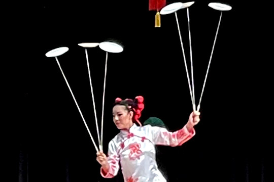 How to Balance our World and Maintain Balance a woman balancing a series of plates on sticks