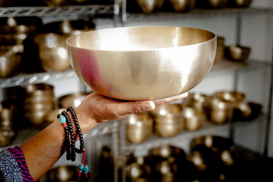 How to Use Crystals and Sound to Amplify Mantras hands holding a large singing bowl