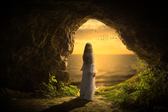 Meeting Resistance: What is Resistance and How Does It Curb Your Success? woman standing in a dark cave looking out into the bright sky