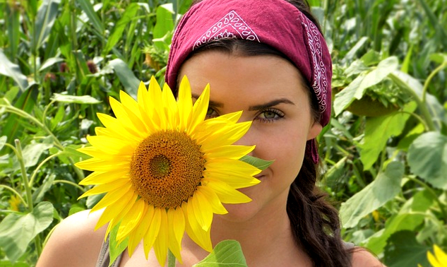 Always You! The Story of Mohan's Journey a woman standing slightly behind a sunflower that is as big as her head