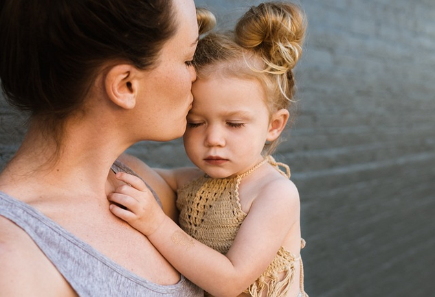 Being Good Parents and Being Human: First Do No Harm mother holding her young child and kissing her on the forehead