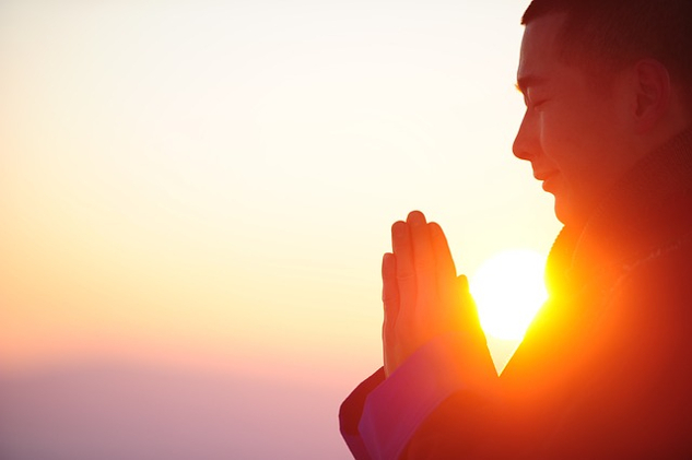 Call God What You Want, Just Call a person with eyes closed and hands in a prayer posture with sun in the background