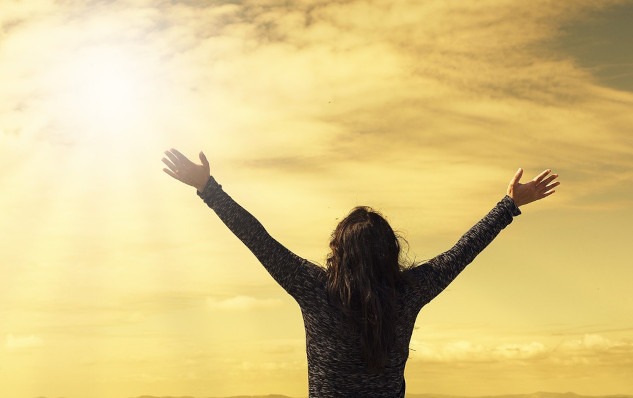 The Healing Power of Energy and Prayer a person facing the sun with arms wide open to the sky