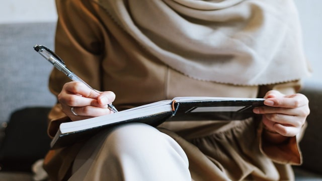 How to Age Well with Dream Journaling a woman sitting writing in her journal